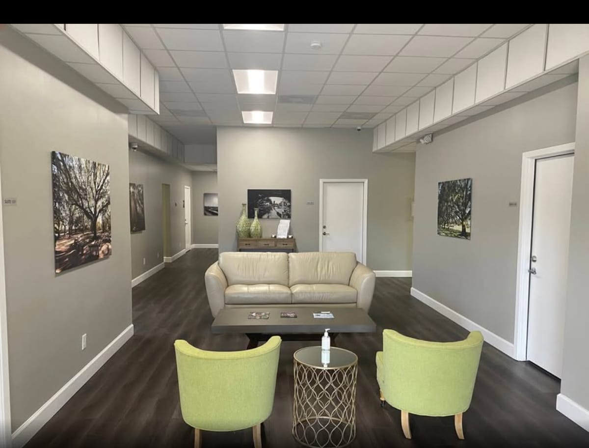 Shared workspace lounge with comfortable seating and bright green accent chairs in the League City Professional Building