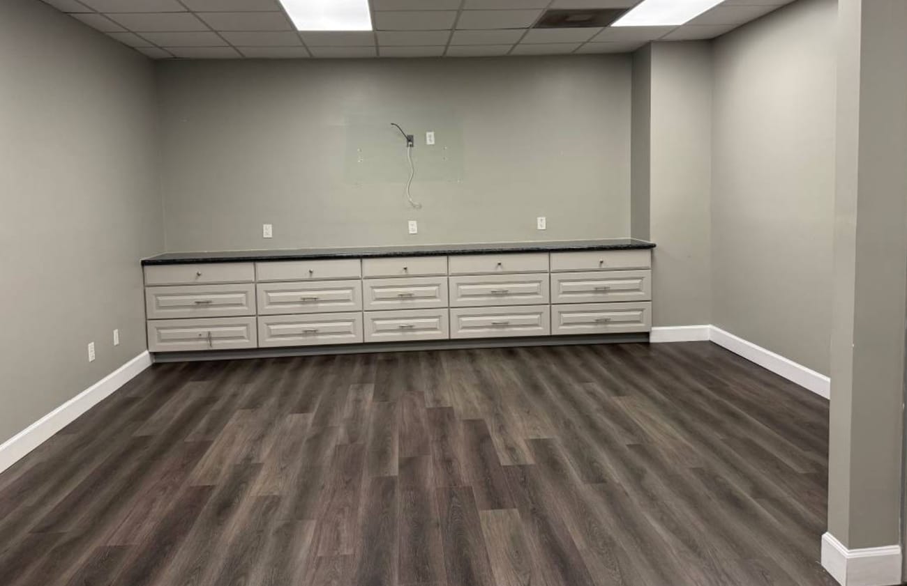 Open shared office suite with wood-look flooring and built-in cabinetry